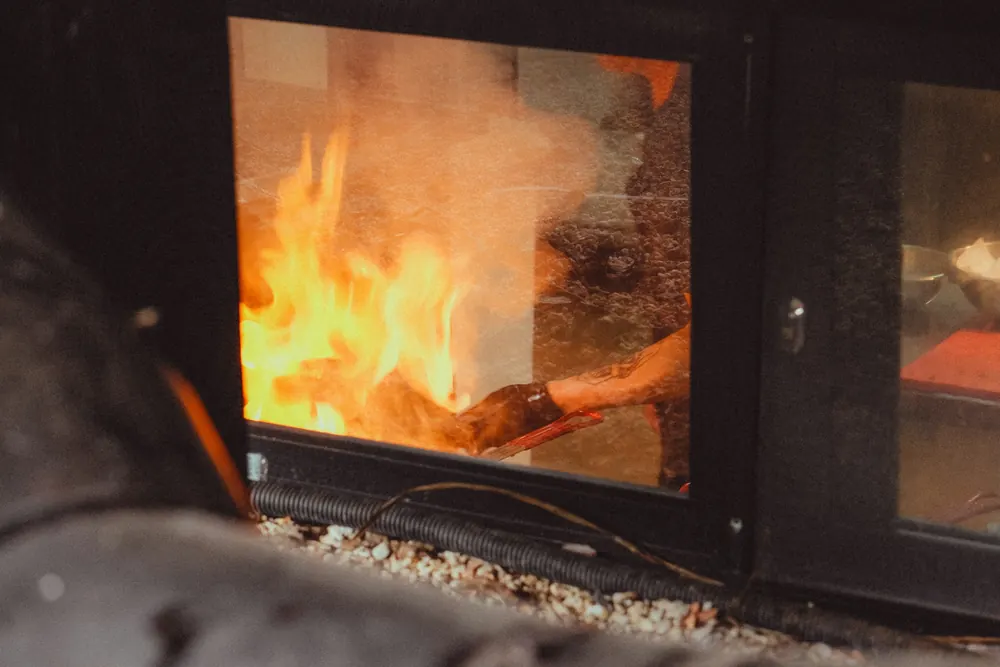 Feu de bois derrière la vitre d'un poêle moderne